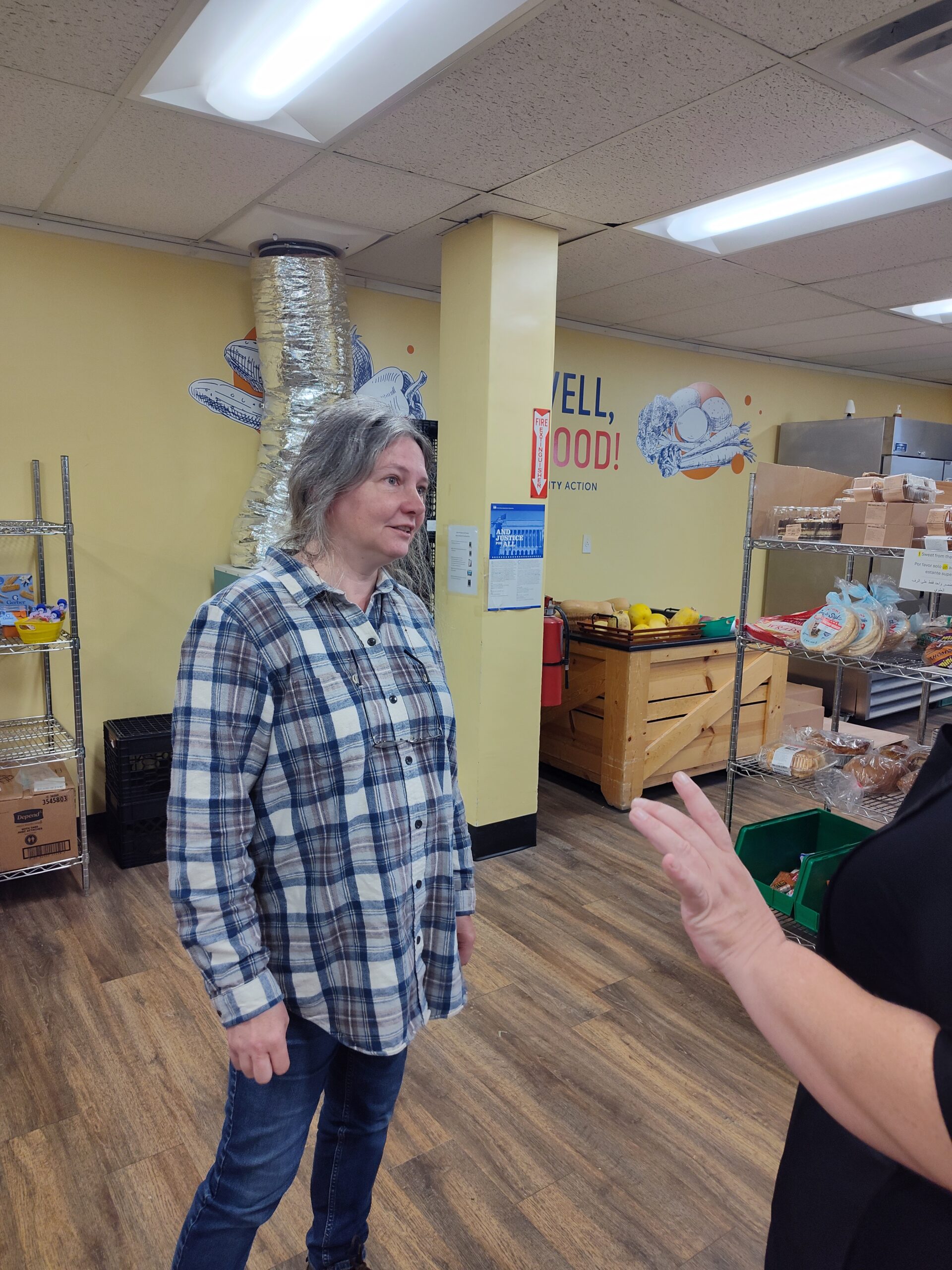 A person in a flannel shirt at a food bank