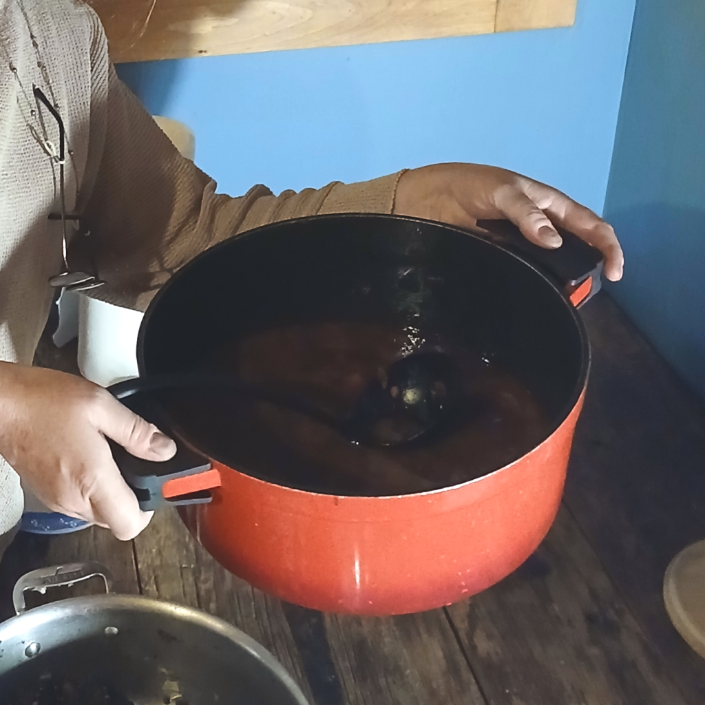 Hands holding a red soup pot